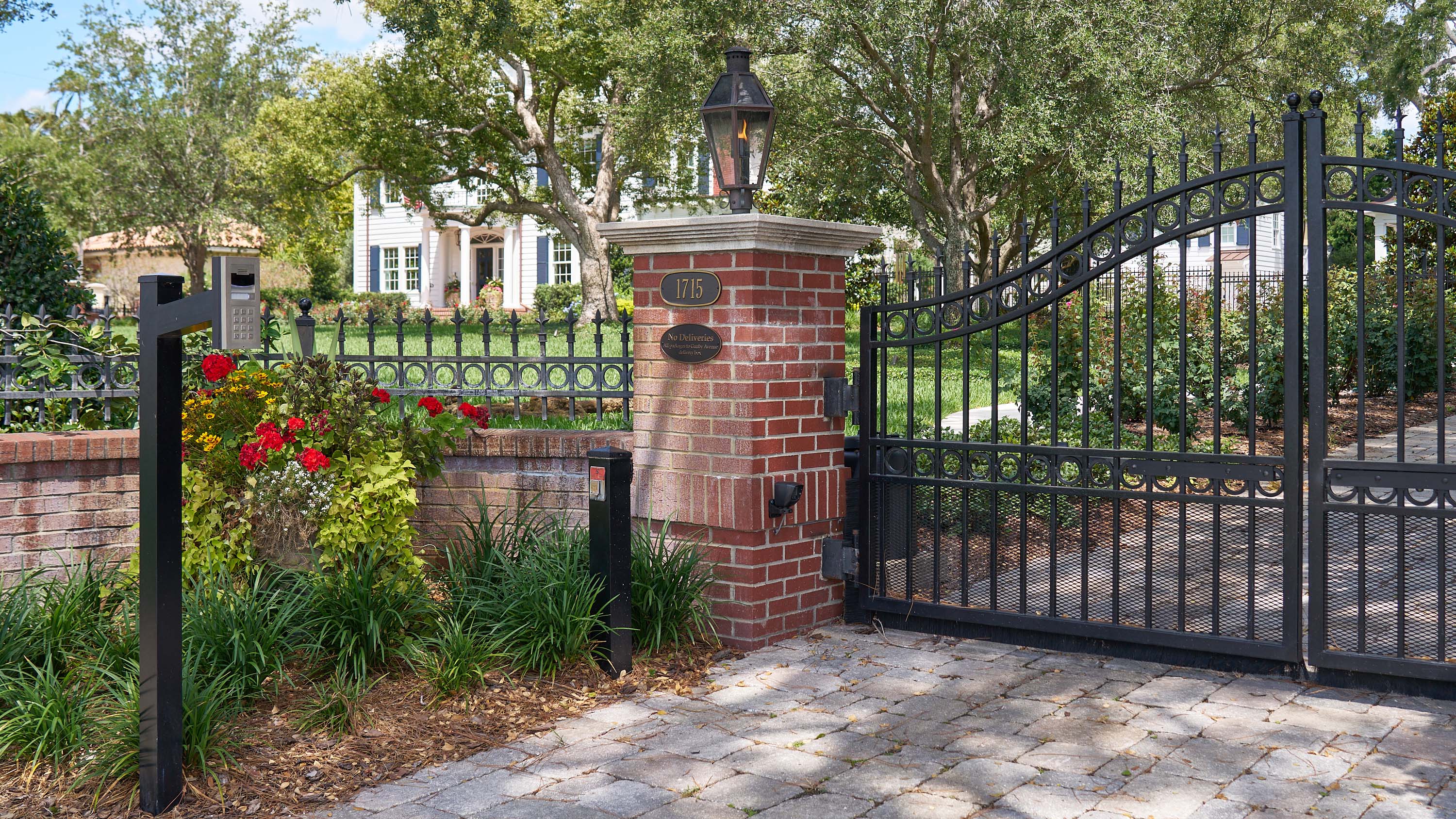 modern home with wooden slatted doors and gated entry with keypad access